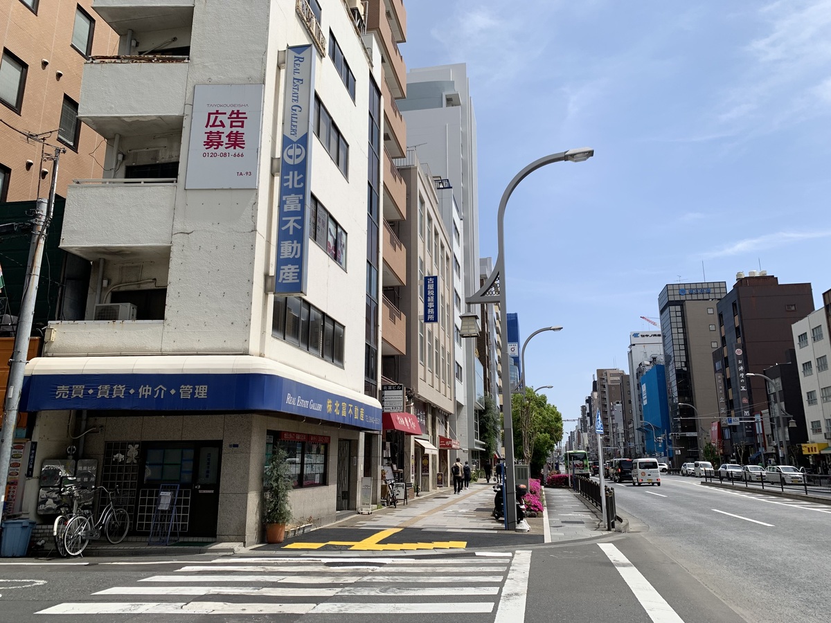 1階が不動産屋の白いビルがございます